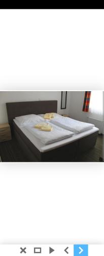Bett in einem Zimmer mit Avertisation für in der Unterkunft HOTEL Eisenbahn in Crailsheim