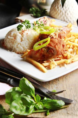 a plate of food with rice and meat and french fries at Fordan Hotel Pécs in Pécs