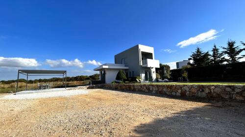 un edificio con un muro di pietra di fronte a un edificio di Selene a modern villa with private pool a Stavros