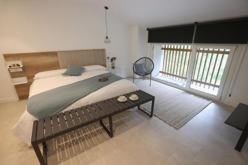 een slaapkamer met een groot bed en een stoel bij GOIZARTE Apartamentos turísticos rurales. 