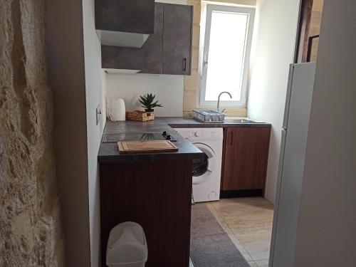 Beautiful 1-Bed Apartment in Hal Qormi في Qormi: مطبخ صغير مع مغسلة وثلاجة