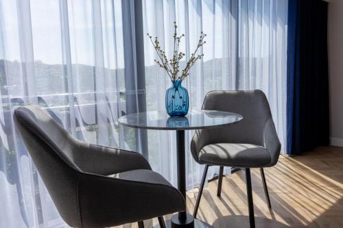 a table with two chairs and a vase on it at Oban Apartments in Oban