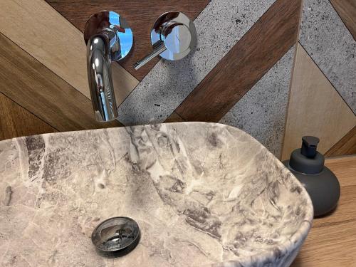 a marble sink in a bathroom with a faucet at Apartamenty Skórzewo in Skórzewo