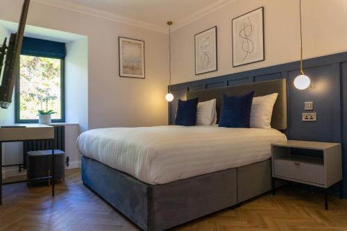 a bedroom with a large bed with blue walls at Oban Apartments in Oban