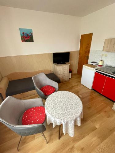 a living room with a table and chairs and a kitchen at Ubytovanie Marta Kováčová in Bešeňová