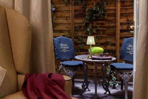 a room with two chairs and a table with a lamp at Hôtel Da Vinci & Spa in Paris