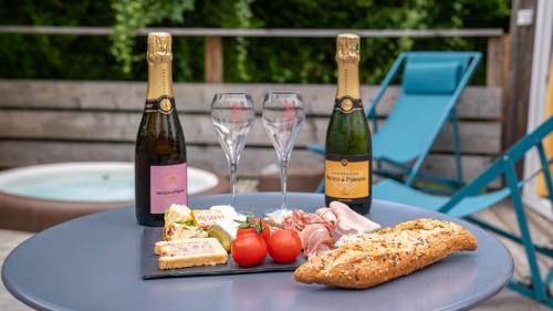 a table with two bottles and two glasses of wine at Le Village de la Champagne - Slowmoov in Bar-sur-Aube