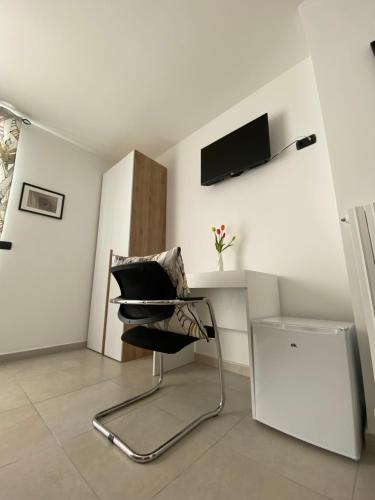 Habitación con silla y TV en la pared. en Poggiofranco Apartaments, en Bari