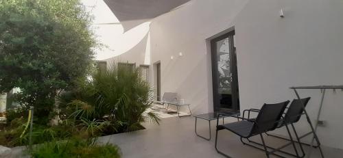 a patio with chairs and plants in a building at Patio 101 in San Vito lo Capo