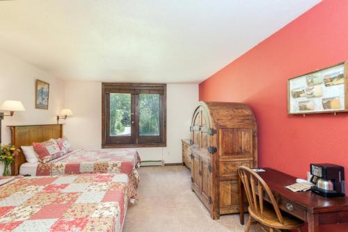 1 dormitorio con 2 camas y escritorio con escritorio en Manitou Lodge 2 Hotel Room, en Telluride