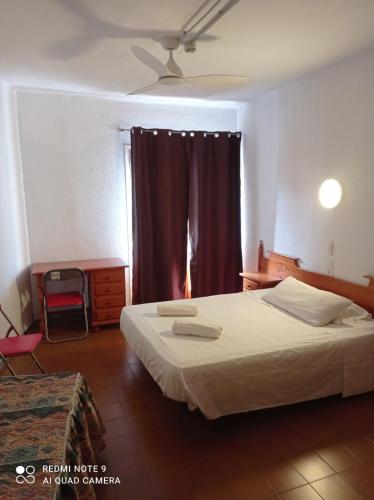 a bedroom with a large bed and a window at Pensión Juan Ramón in Lloret de Mar