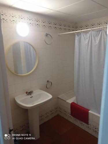 a bathroom with a sink and a mirror and a shower at Pensión Juan Ramón in Lloret de Mar