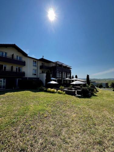 a large building with the sun in the sky at Best Western Plus Hôtel Gergovie in Pérignat-lès-Sarliève