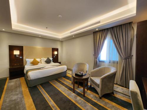a hotel room with a bed and a chair at دار ود للشقق المخدومة Dar Wed in Jeddah