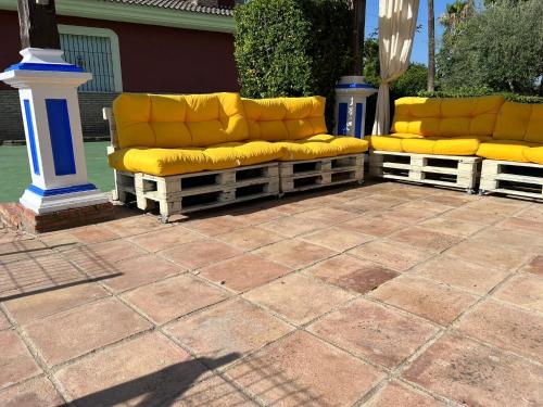 2 divani gialli sono posti su un patio di Hacienda El chorlo a Cordoba