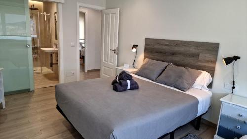 a bedroom with a large bed with a purse on it at Soleado a un paseo de la Catedral in Santiago de Compostela