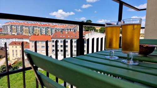 two glasses of beer sitting on a table on a balcony at Soleado a un Paseo de la Catedral in Santiago de Compostela