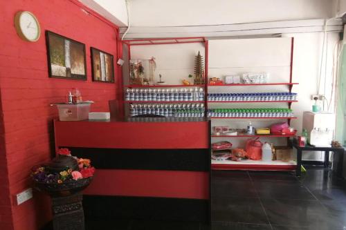 a room with a red wall with a refrigerator at Dongfang Motel in Kuala Lumpur