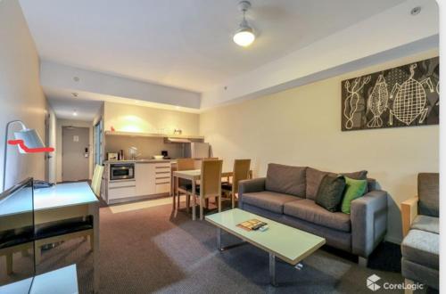 a living room with a couch and a table at Darwin Harbour Suite in Darwin