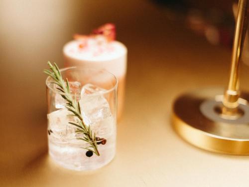 a glass of water with rosemary on a table at Schgaguler Hotel in Castelrotto