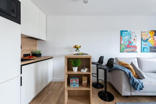 een woonkamer met een bank en een tafel bij Wrzeciono 12 - Piękny apartament obok Szpitala Bielańskiego oraz AWF, bezpłatna strefa parkowania - 400m do stacji metra - Good Apartments in Warschau