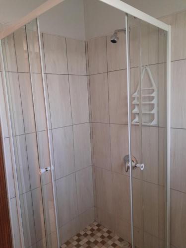 a shower with a glass door in a bathroom at Eve's Accommodation in Windhoek