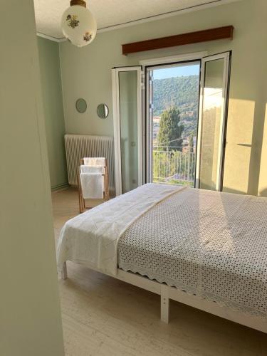 a bedroom with a bed and a large window at Marble's Residence in Argostoli