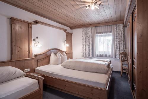 een slaapkamer met 2 bedden en een raam bij Huber Apartments in Kappl