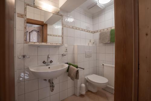 a white bathroom with a sink and a toilet at Huber Apartments in Kappl