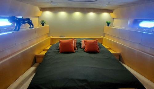 コゴランにあるHébergement Yachtのオレンジ色の枕2つが備わるドミトリールームのベッド1台分です。