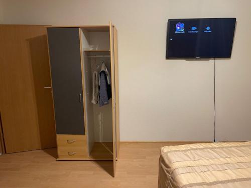 a bedroom with a wardrobe and a television on a wall at Appartement Trier Zentrum ( mit Mosel Blick ) in Trier
