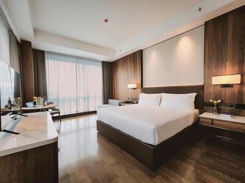 a bedroom with a large white bed and a desk at VM Hotel in Phnom Penh