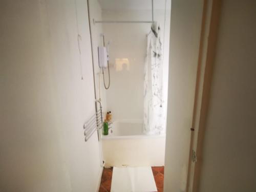 een witte badkamer met een bad en een wastafel bij Family Room - Sutherland Place in Derby