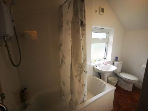 a bathroom with a tub and a toilet and a sink at Family Room - Sutherland Place in Derby