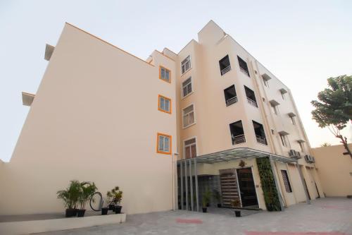 a large white building with plants in front of it at Flagship Jp Residency in Singapperumālkovil