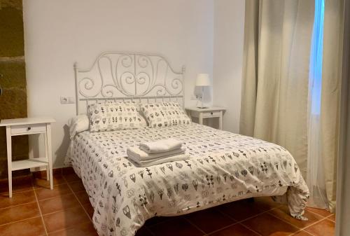 a bedroom with a bed with a white comforter at Casa Monegros in Lastanosa