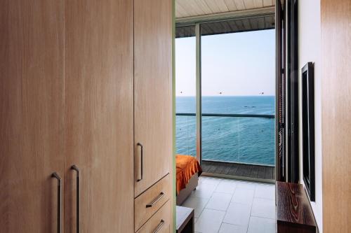 a bedroom with a view of the ocean from a balcony at Villa Aquamarine in Pomos