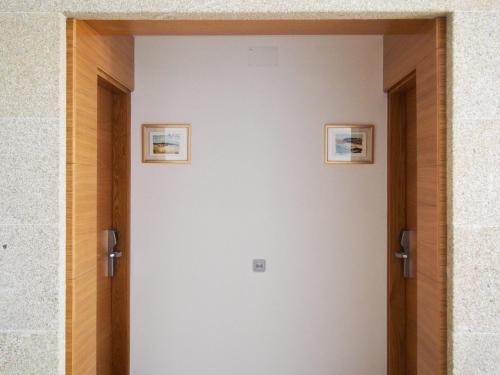 two doors to a room with two pictures on the wall at HOTEL BOUTIQUE VILAVELLA in O Grove