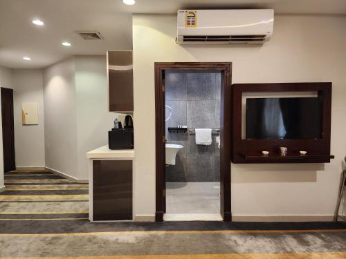 a bathroom with a sink and a tv in a room at دار ود للأجنحة الفندقية Dar Wed in Jeddah