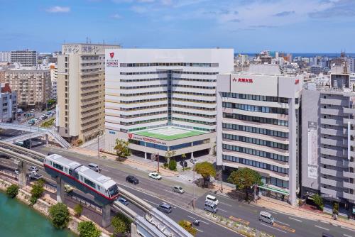 una ciudad con un tren delante de un edificio en Okinawa NaHaNa Hotel & Spa, en Naha