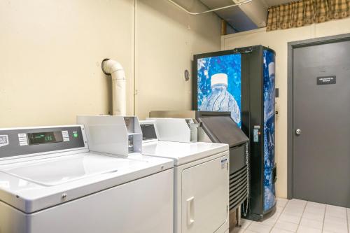 a laundry room with machines and a picture of a man at Lift House Lodge, Pet Friendly Studio Condo in Vail