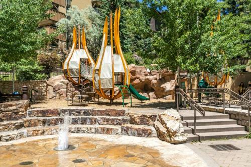 a playground with slides and a water fountain in a park at Lift House Lodge, Pet Friendly, Premium Studio Condo in Vail