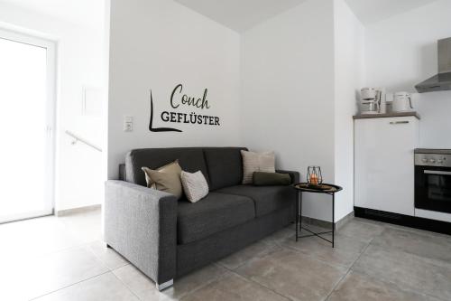 a couch in a living room with a kitchen at Ferienwohnung Dohr in Kundl