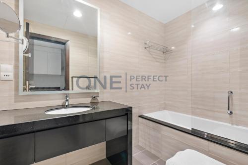 La salle de bains est pourvue d'un lavabo, d'une baignoire et d'un miroir. dans l'établissement Posh Studio - Comfort and Peace - Bills Included, à Dubaï