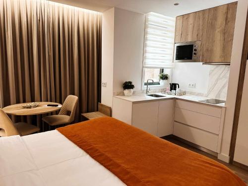 a hotel room with a bed and a kitchen and a table at Coração do Tua Hotel in Mirandela