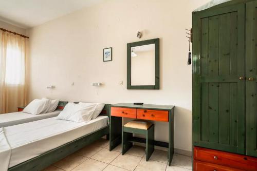 a bedroom with two beds and a desk and a mirror at Anemona studio A in Katelios