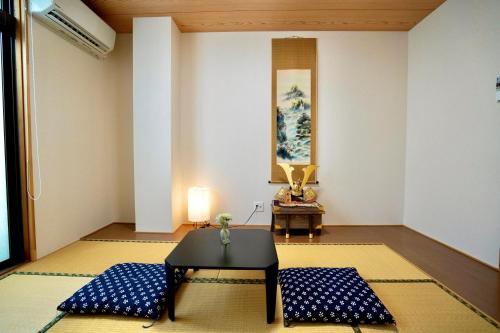 a living room with a table and blue cushions at Nenenomichi in Kyoto