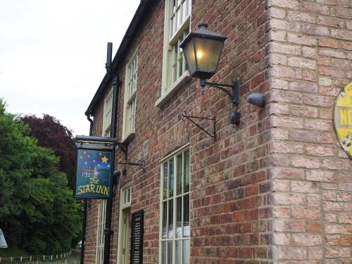 un edificio de ladrillo con un cartel en el costado en The Star Inn en North Dalton