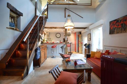 un salon avec un escalier et un canapé dans l'établissement La porcherie du pet en l'air, à Saint-Malo