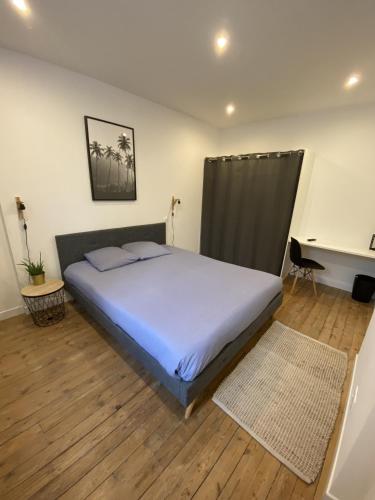 une chambre avec un grand lit et un bureau dans l'établissement Appartement 97 M2 proche Puy du fou, à Saint-Laurent-sur-Sèvre